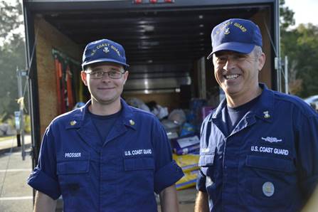 Petty Officer 1st Class James Prosser and Master Chief Petty Officer Louis Coleman load Coleman's trailer with donations at Coast Guard Sector North Carolina in Wilmington, Oct. 16, 2016. Prosser organized the donations of food, water and other necessities for residents of Lumberton, North Carolina, impacted by floodwaters after Hurricane Matthew. (U.S. Coast Guard photo by Petty Officer 2nd Class Nate Littlejohn/Released)