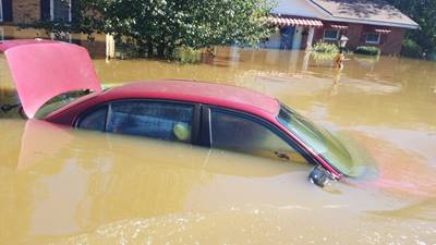 A flooded car near a flooded home represent only a small portion of the damage in Lumberton, North Carolina, Oct. 10, 2016. The Lumber River flooded the city after Hurricane Matthew. (U.S. Coast Guard photo by Petty Officer 1st Class James Prosser/Released)