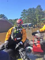 A New York City rescue worker aboard a boat searches for flood victims in Lumberton, North Carolina, Oct. 10, 2016. The Lumber River flooded the city after Hurricane Matthew. (U.S. Coast Guard photo by Master Chief Petty Officer Louis Coleman/Released)